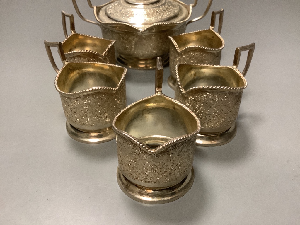 A Persian white metal sugar bowl and cover and five matching tea glass holders